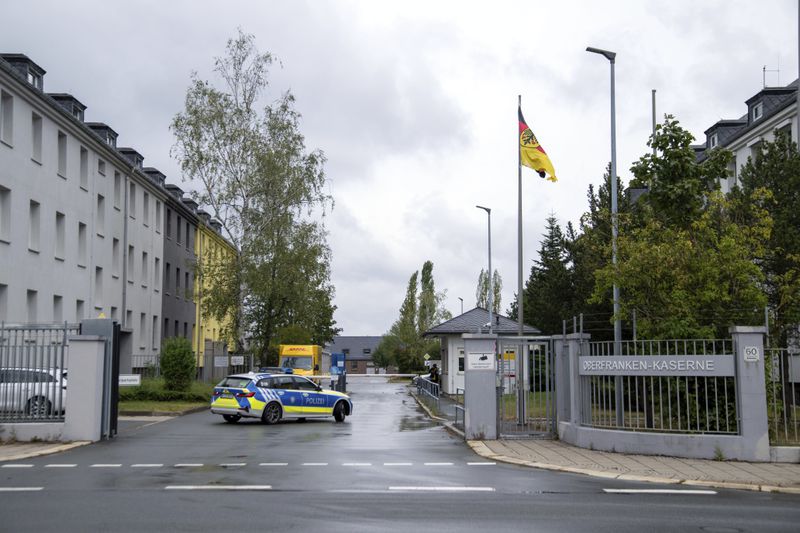 A police car drives on the grounds of the Upper Franconia barracks, in Hof, Germany. Investigators in Bavaria have arrested a 27-year-old Syrian man for planning to attack Bundeswehr soldiers in Upper Franconia. (Pia Bayer/dpa via AP)