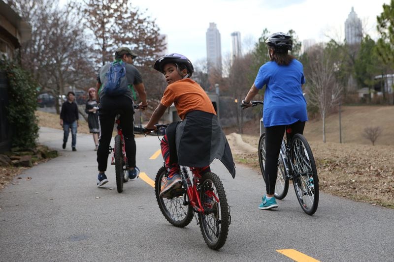 Benjamin Blackburn, 8, looks back as his father, Ben Blackburn, 45, and sister Lindsay Blackburn, 15, ride off on the Beltline loop in Atlanta. They're in the heart of the 5th Congressional District, an area Donald Trump in 2016 described as in "horrible shape and falling apart" while venting at that time against U.S. Rep. John Lewis. (HENRY TAYLOR / HENRY.TAYLOR@AJC.COM)