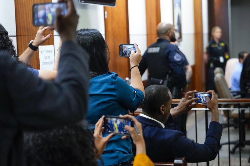 Reporters use their phones to take photos of Johan Jose Rangel-Martinez, one of the two men accused of killing 12-year-old Jocelyn Nungaray, as he is led from the courtroom on Tuesday, June 25, 2024 in Houston. Capital murder charges have been filed against Johan Jose Rangel Martinez and Franklin Jose Pena Ramos, in the strangulation death of the 12-year-old. (Brett Coomer/Houston Chronicle via AP)