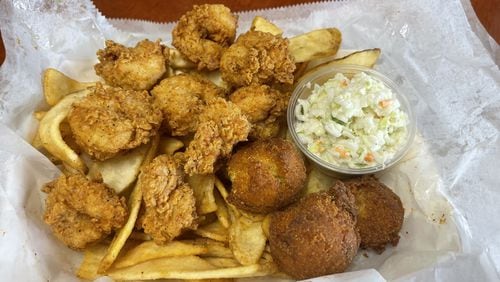 The Po'Boy Shop's coleslaw, shown here with the fried shrimp platter accompanied by hush puppies and Cajun-seasoned fries. 
(Courtesy of the Po'Boy Shop)