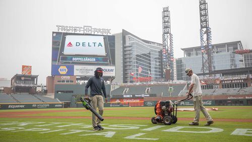 Members of the grounds crew prepare the field for opening week at Truist Park on Wednesday, April 6, 2022, in Atlanta.  Branden Camp/For the Atlanta Journal-Constitution
