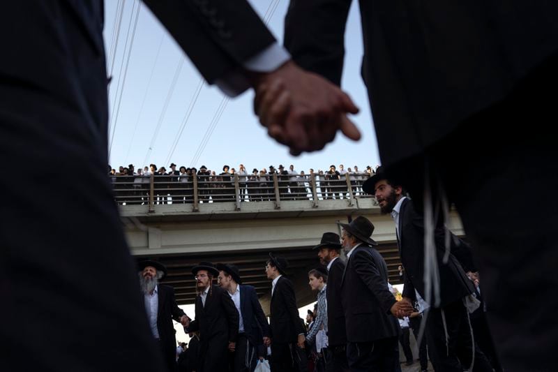 Ultra-Orthodox Jewish men block a highway as they take part in a protest against army recruitment in Bnei Brak, Israel, Thursday, June 27, 2024. Israel's Supreme Court unanimously ordered the government to begin drafting ultra-Orthodox Jewish men into the army, a landmark ruling seeking to end a system that has allowed them to avoid enlistment into compulsory military service. (AP Photo/Oded Balilty)