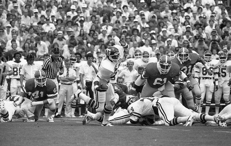 Georgia Bulldogs defensive lineman Eddie Weaver (61) in the backfield to help with a tackle against Texas A&M at Sanford Stadium on Sept. 13, 1980. (AJC file photo)