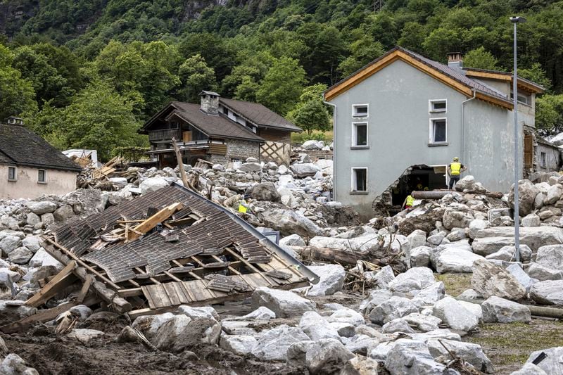 Rescue workers inspect the site of a landslide, caused by severe weather and heavy rain in the Misox valley, in Sorte village, Lostallo, southern Switzerland on Sunday June 23, 2024. Authorities in Switzerland say rescuers have found the body of one of three people who had gone missing on Saturday after massive thunderstorms and rainfall in the southeast of the county caused a rockslide. (Michael Buholzer/Keystone via AP)
