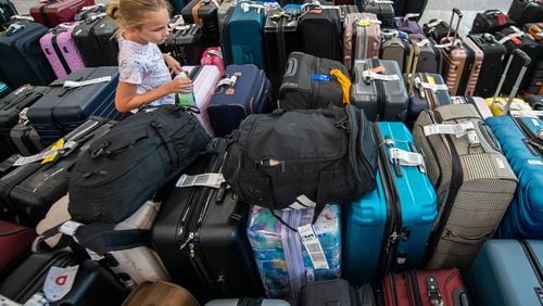 Brooke Render, 8, from Evansville, Indiana looks for her luggage at the south terminal baggage claim area in Hartsfield-Jackson Atlanta International Airport in Atlanta on Sunday, July 21, 2024.  (Ziyu Julian Zhu / AJC)