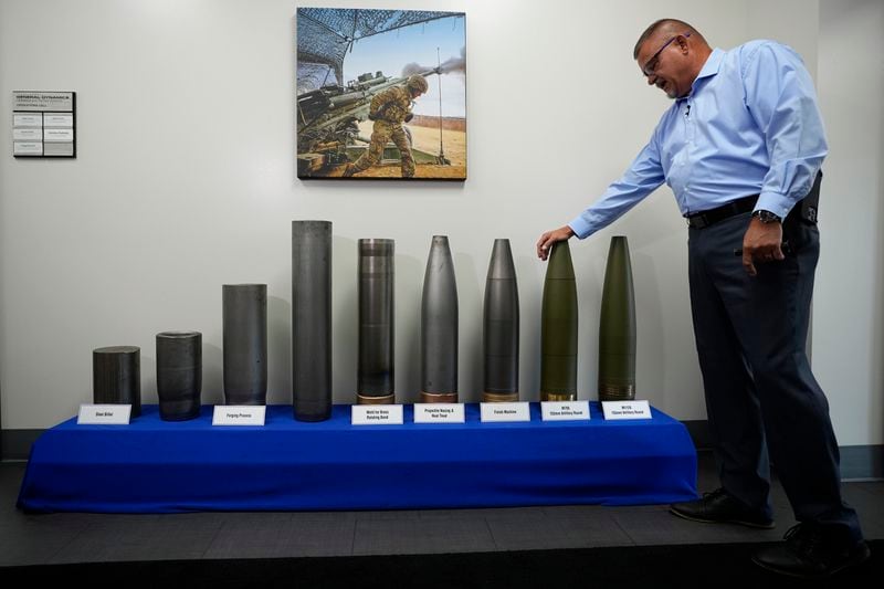 Richard Hansen, a Navy veteran and the Army commander's representative at the Scranton Army Ammunition Plant leans on a display during a tour of the manufacturing process of 155 mm M795 artillery projectiles, Tuesday, Aug. 27, 2024, in Scranton, Pa. (AP Photo/Matt Slocum)