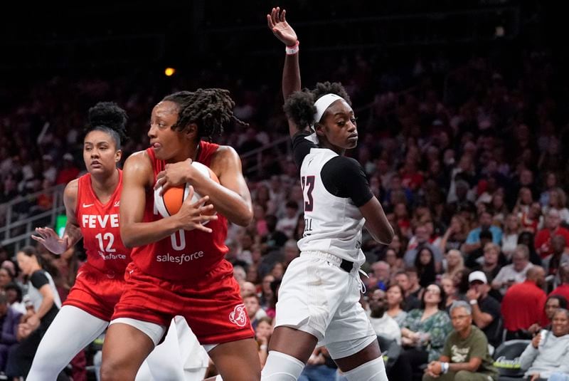 Indiana Fever guard Kelsey Mitchell (0) holds the ball against Atlanta Dream guard Maya Caldwell (33) in the second half of an WNBA basketball game against the Monday, Aug. 26, 2024, in Atlanta. (AP Photo/Brynn Anderson)