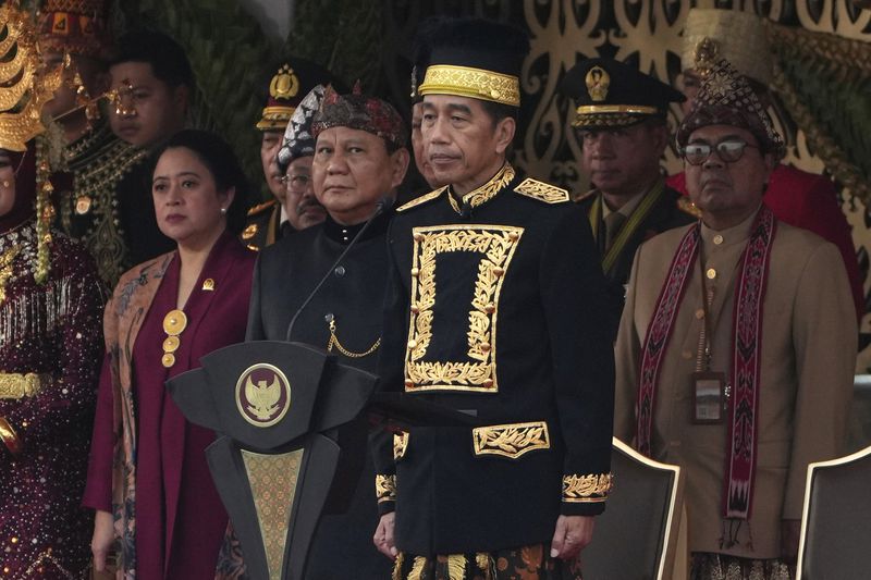 Indonesian President Joko Widodo, center, Defense Minister and president-elect Prabowo Subianto, second left, and House Speaker Puan Maharani attend the ceremony marking Indonesia's 79th anniversary of independence at the new presidential palace in its future capital of Nusantara, a city still under construction in Penajam Paser Utara on the island of Borneo, Saturday, Aug. 17, 2024. (AP Photo/Achmad Ibrahim)