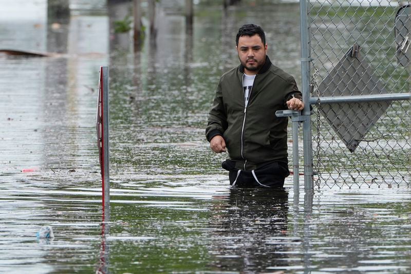 Francisco Lopez stands near the flooded parking lot of his apartment building, Thursday, June 13, 2024, in Hallandale, Fla. A tropical disturbance has brought a rare flash flood emergency to much of southern Florida. Floridians prepared to weather more heavy rainfall on Thursday and Friday. (AP Photo/Marta Lavandier)