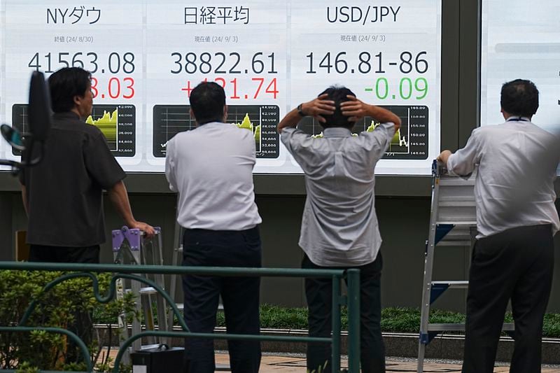 People look at an electronic stock board showing Japan's Nikkei index at a securities firm Tuesday, Sept. 3, 2024, in Tokyo. (AP Photo/Eugene Hoshiko)