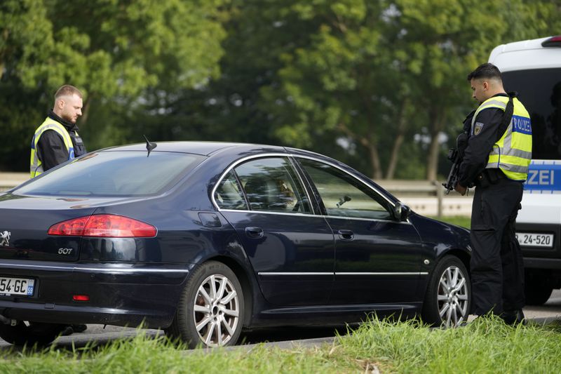 German police check the details of a French car near the border to Belgium in Aachen, Germany, Monday, Sept. 16, 2024, as Germany begins carrying out checks at all its land borders. (AP Photo/Martin Meissner)