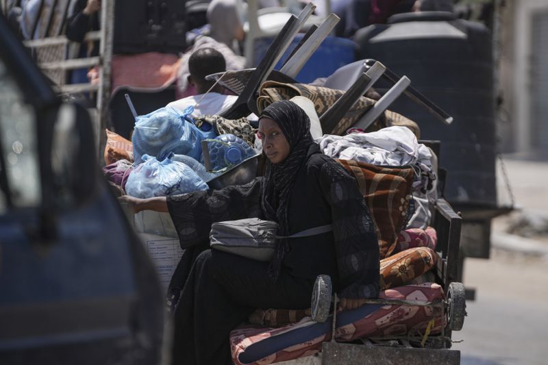 A Palestinian woman evacuates Maghazi refugee camp in the central Gaza Strip, as part of a mass evacuation ordered by the Israeli military ahead of an operation, Saturday, Aug. 17, 2024. (AP Photo/Abdel Kareem Hana)