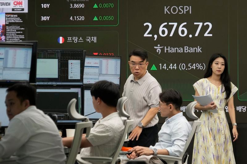 Currency traders work near a screen showing the Korea Composite Stock Price Index (KOSPI) at the foreign exchange dealing room of the KEB Hana Bank headquarters in Seoul, South Korea, Friday, Aug. 30, 2024. (AP Photo/Ahn Young-joon)