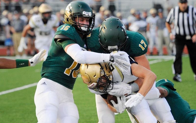 J.D. Bertrand (16) of Blessed Trinity tackles St. Pius running back Harrison Bernhardt in a 2015 contest.  (John Amis/AJC)