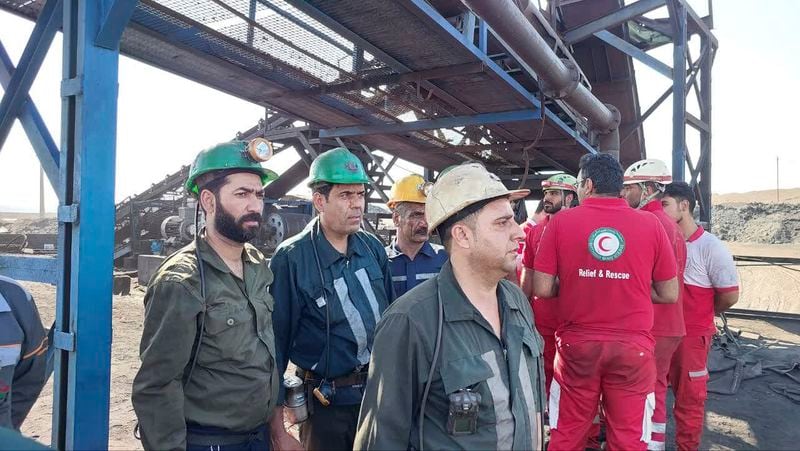 In this photo released on Tuesday, Sept. 24, 2024, by Iranian Interior Ministry, miners and rescue personnel stand at the site of a coal mine where methane leak sparked an explosion on Saturday, in Tabas, some 335 miles (540 kilometers) southeast of the capital Tehran, Iran. (Iranian Interior Ministry via AP).