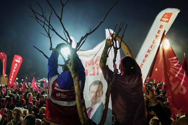 Protesters hang a banner with the image of Istanbul's Mayor Ekrem Imamoglu as they protest against his arrest, in Istanbul, Turkey, Saturday, March 22, 2025. (AP Photo/Francisco Seco)