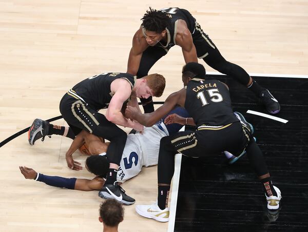 Atlanta Hawks defenders Kevin Huerter (clockwise from left), De’Andre Hunter and Clint Capela force a jump ball as they defend Minnesota Timberwolves guard Malik Beasley Monday, Jan. 18, 2021, at State Farm Arena in Atlanta.  (Curtis Compton / Curtis.Compton@ajc.com)