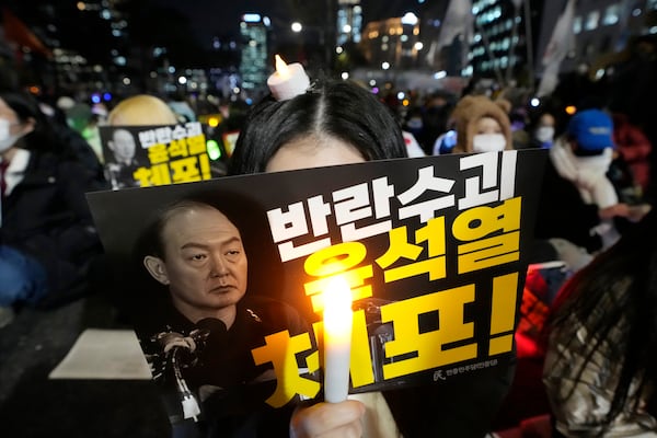 A participant holds a banner with writing reading "Arrest the rebellion leader Yoon Suk Yeol", during a rally to demand South Korean President Yoon Suk Yeol's impeachment outside the National Assembly in Seoul, South Korea, Wednesday, Dec. 11, 2024. (AP Photo/Ahn Young-joon)