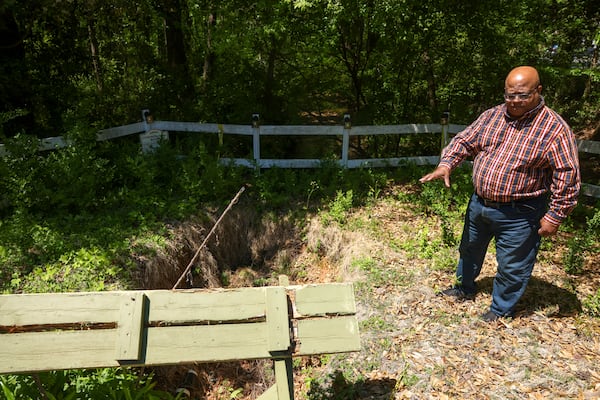 Tony Dunbar discusses the sink hole in the common area at Willow Brook in Roswell. Also shown is a picnic table that was destroyed by the sink hole. Jason Getz / Jason.Getz@ajc.com)
