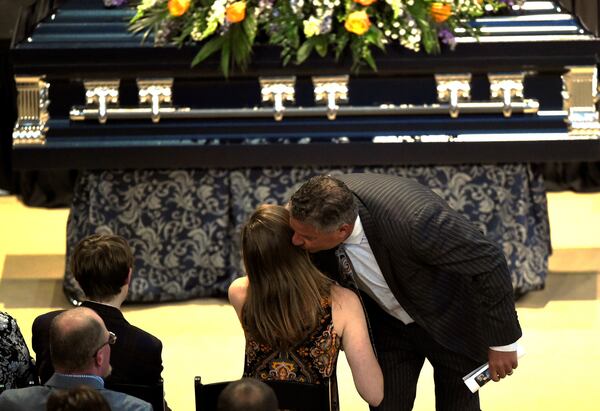 Following his eulogy for team broadcaster Rod Bramblett, Auburn basketball coach Bruce Pearl consoles Bramblett's children, daughter Shelby, seated next to son Joshua. (Photo by Todd J Van Emst/Auburn Athletics)