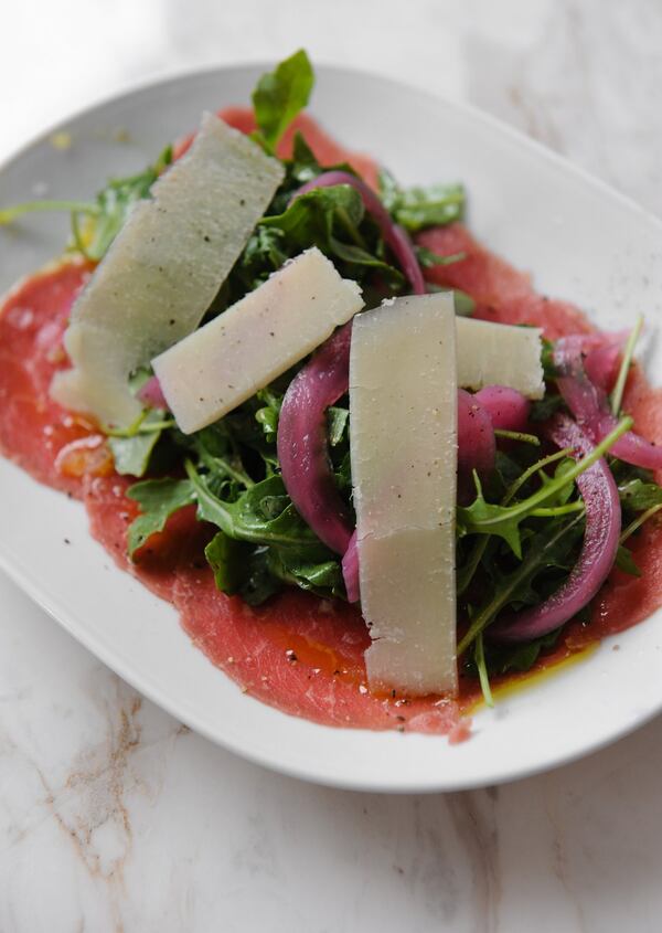 Beef carpaccio with arugula, pickled red onion, Parmesan and olive oil on the small menu at Amer. (Beckysteinphotography.com)