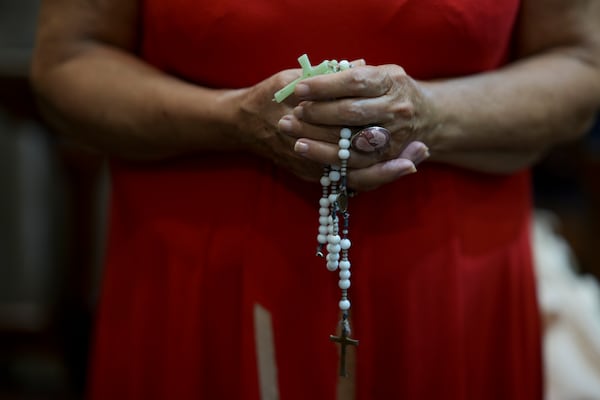 A woman holds a rosary during a Mass for Pope Francis' health at the Cathedral in Buenos Aires, Argentina, Sunday, Feb. 23, 2025. (AP Photo/Natacha Pisarenko)