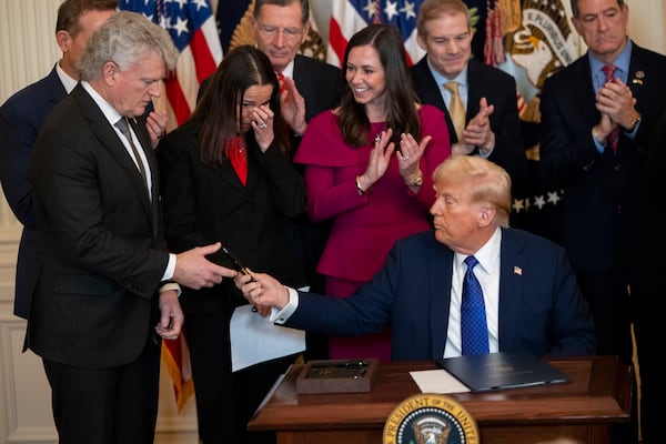 President Donald Trump gives a pen to U.S. Rep. Mike Collins, a Republican from Jackson, after signing the Laken Riley Act at the White House last week. Collins was the primary sponsor of the bill. (Nathan Posner for the AJC)