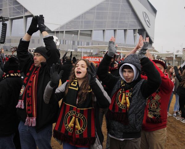 Fans cheer in anticipation for the victory rally stage at the Home Depot Backyard where the parade will end and a pep rally will begin. (Alyssa Pointer/AJC Staff)