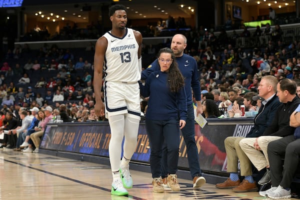 Memphis Grizzlies forward Jaren Jackson Jr. (13) is helped off the court in the first half of an NBA basketball game against the Atlanta Hawks, Monday, March 3, 2025, in Memphis, Tenn. (AP Photo/Brandon Dill)