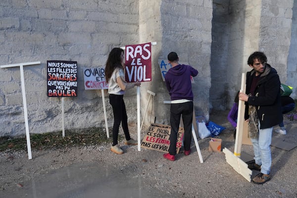 Activists prepare posters before a women's rights demonstration, Saturday, Dec. 14, 2024 in Avignon, southern France, where the trial of dozens of men accused of raping Gisèle Pelicot while she was drugged and rendered unconscious by her husband is taking place. (AP Photo/Aurelien Morissard)