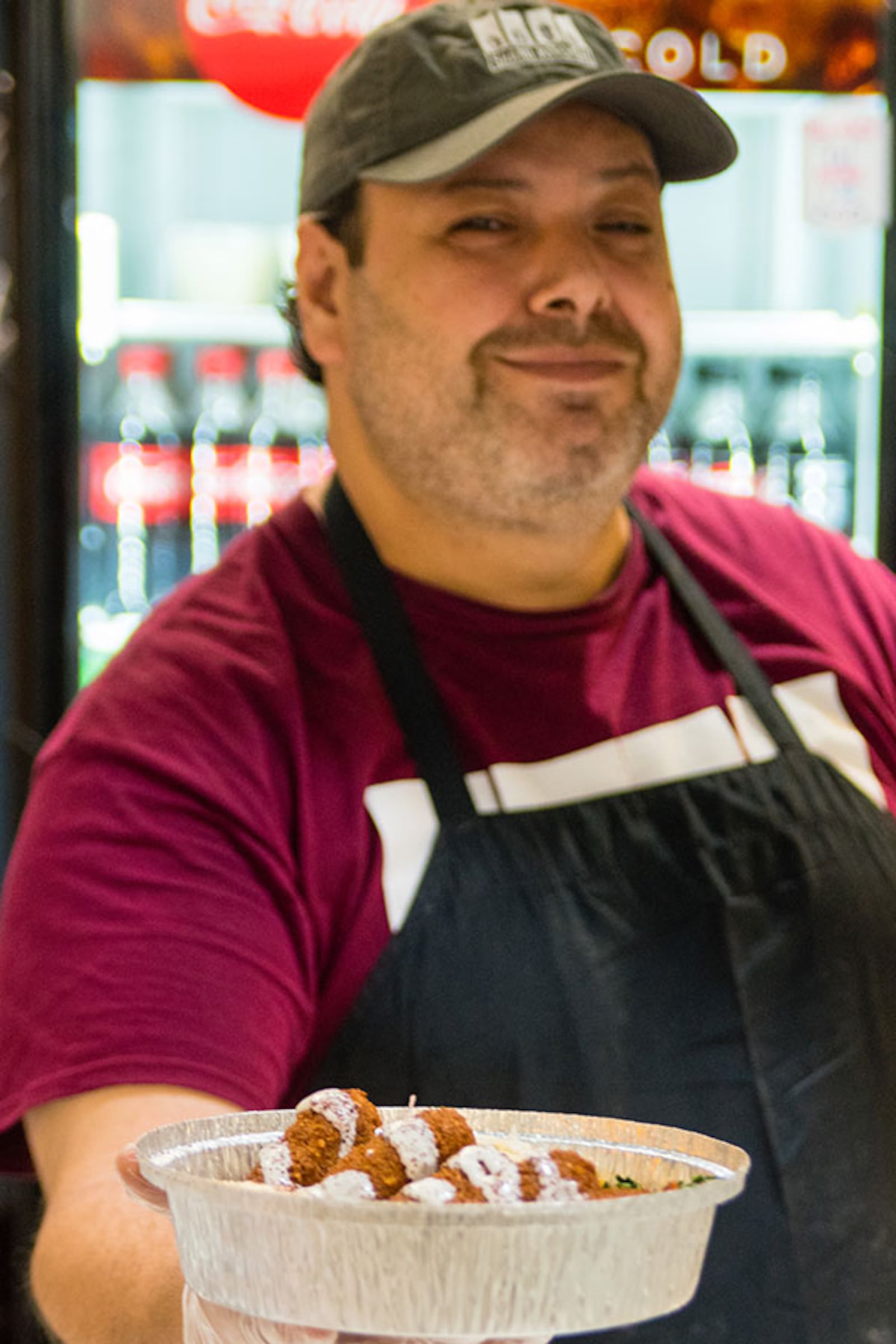 Samer Tammouor offers a plate of the Veggie Feast, which includes hummus, baba ganough, tabbouleh salad, fattoush salad and five falafels. CONTRIBUTED BY HENRI HOLLIS