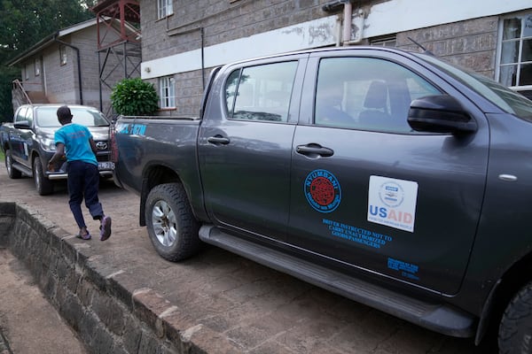 A child run past USAID-donated vehicles at the Nyumbani Children's Home orphanage which is heavily reliant on foreign donations in Nairobi, Kenya Thursday, Oct. 6, 2025. (AP Photo/Brian Inganga)