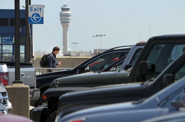 SECONDARY PHOTO: April 23, 2013 - Atlanta, Ga: With the control tower in the background, a traveler walks toward the north terminal from the parking deck at Hartsfield-Jackson Atlanta International Airport Tuesday morning in Atlanta, Ga., April 23, 2013. Nearly a year after the Atlanta airport opened its new international terminal, it is already planning for the next expansion. Hartsfield-Jackson International Airport's master plan study shows the airport will soon need more parking, and will also need more people-mover train capacity inside the terminal, more security screening line space, more gates and more airfield capacity - such as another runway -- in the next 20 years JASON GETZ / JGETZ@AJC.COM