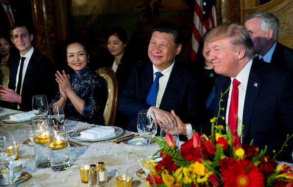 President Donald Trump and President Xi Jinping of China shake hands during a dinner at Trump's Mar-a-Lago resort April, 6, 2017. At left are Jared Kushner, Trump's son-in-law, and Peng Liyuan, Xi's wife. (Doug Mills / The New York Times)