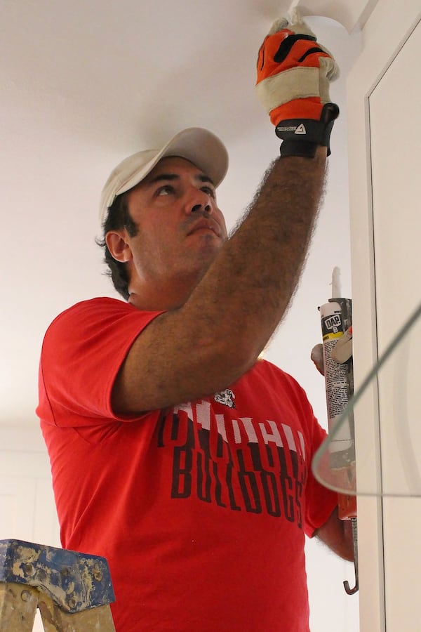 Erick Von Borries, a ProServe Home Solutions technician, caulks the molding of a house that Kismet Holdings, Inc. is preparing for the market in Atlanta. Jenna Eason / Jenna.Eason@coxinc.com