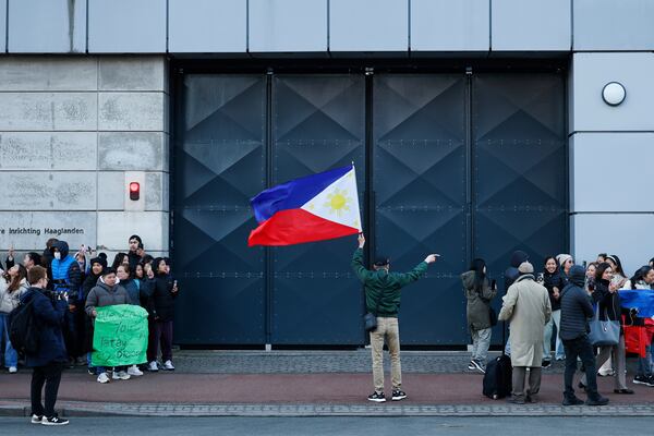 A supporter of former Philippine President Rodrigo Duterte waves a flag during a demonstration outside the International Criminal Court detention center near The Hague in Scheveningen, Netherlands, Wednesday, March 12, 2025. (AP Photo/Omar Havana)