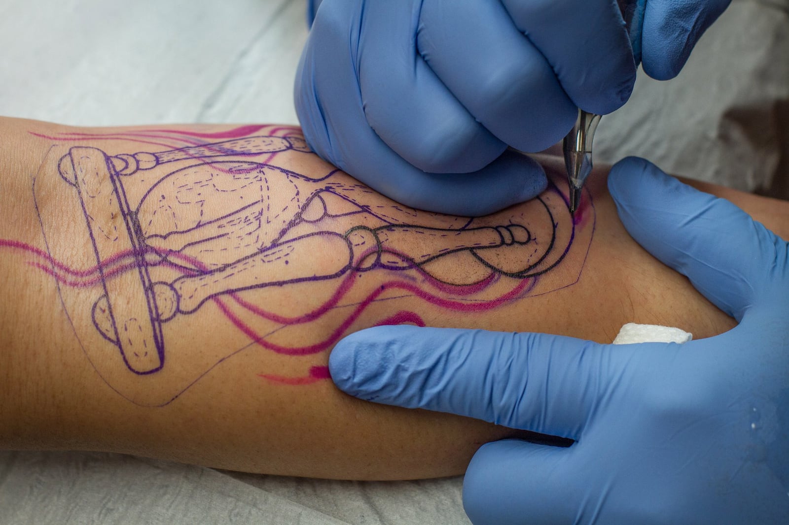 Villa Rica Ink’s Joey Hulsey works to cover the signs of the painful past of a reformed drug addict at his shop. CONTRIBUTED BY STEVE SCHAEFER