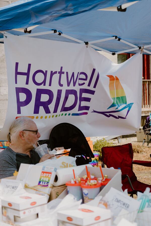 Alan Reeves, husband of Hartwell Pride board member Elizabeth Bryant-Reeves, sits behind raffle prizes at the April event. Courtesy of Kali Thomas Photography