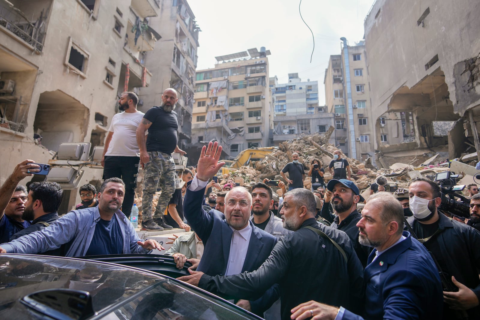 Iran's parliament speaker Mohammad Bagher Qalibaf waves to residents as visit the site of Thursday's Israeli airstrike, in Beirut, Lebanon, Saturday, Oct. 12, 2024. (AP Photo/Hassan Ammar)