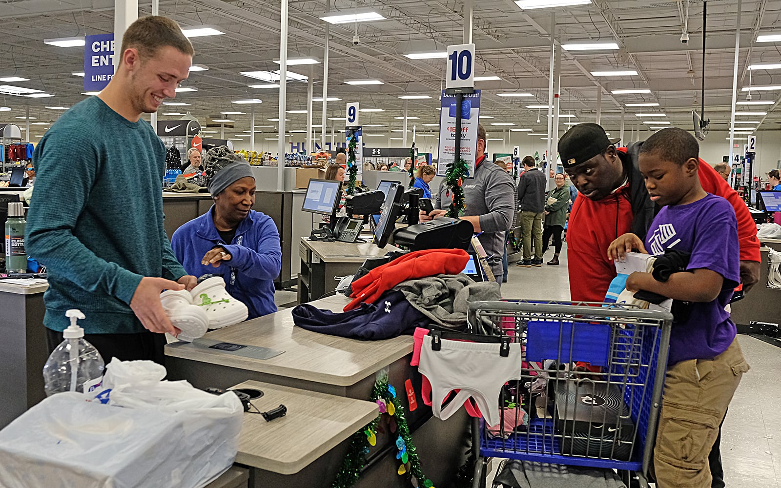 The Ollie family checks out with help from UGA quarterback Carson Beck and Academy employee Gwen Potts after the Boys and Girls Club shopping spree at Academy. Carson Beck was on site at an Athens Academy store Sunday December 17, 2023, to give out gift cards to lucky members of area Boys and Girls Clubs. Academy contributed $200 for each child and he kicked in $135 more of his own money to help families out. 
Nell Carroll for the Journal-Constitution