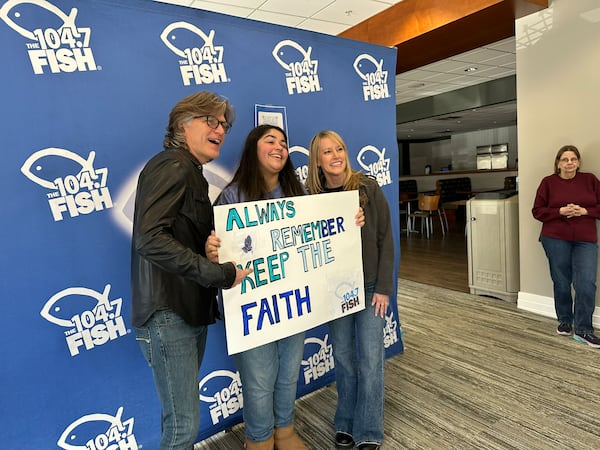 Gianna Molezion, a Kennesaw State University student, held a poster Always & Remember: Keep the Faith" to the Fish 104.7 going away party at Mt. Paran Church featuring the staff, including Kevin Avery and Taylor Scott on Jan. 25, 2025. RODNEY HO/rho@ajc.com