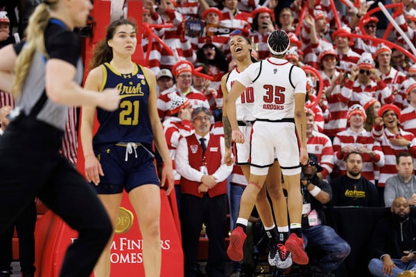 NC State's Aziaha James (10) and Zoe Brooks (35) celebrate behind Notre Dame's Maddy Westbeld (21) in the final moments of double-overtime in an NCAA college basketball game in Raleigh, N.C., Sunday, Feb. 23, 2025. (AP Photo/Ben McKeown)