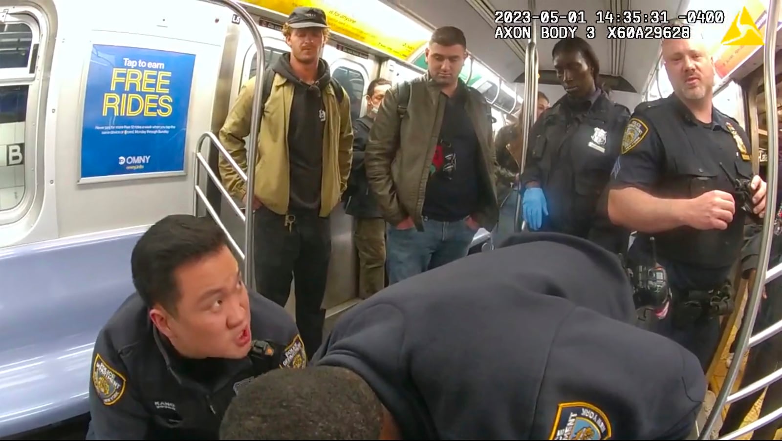 This image from body camera video provided by New York City Police Department, Penny, standing at left, looks on in a New York City subway car as officers attempt to revive Jordan Neely onMay 5, 2023. (New York City Police Department via AP)