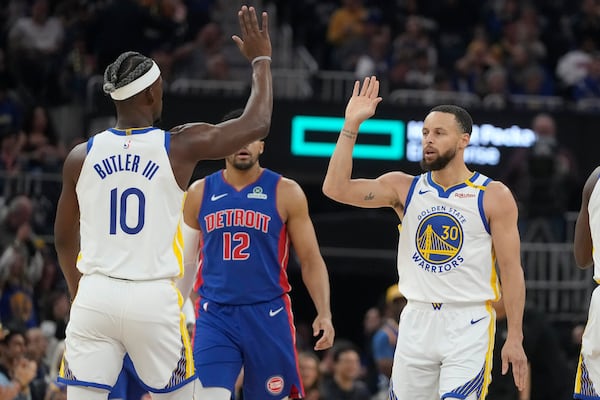 Golden State Warriors guard Stephen Curry (30) is congratulated by forward Jimmy Butler III (10) after making a three-point basket during the first half of an NBA basketball game against the Detroit Pistons in San Francisco, Saturday, March 8, 2025. (AP Photo/Jeff Chiu)