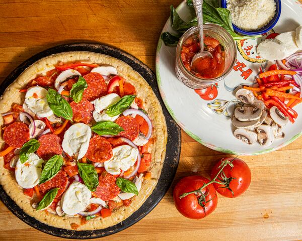 This recipe for homemade supreme pepperoni pizza contains a fraction of the sodium found in takeout pizza. (Food styling by Jennifer Hill Booker / Aaliyah Man for The Atlanta Journal-Constitution)