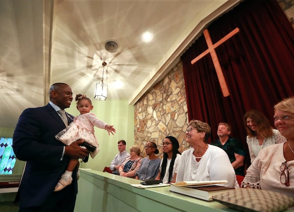 The Reverend Tony Lowden and his daughter Tabitha greet visitors in 2019 in the sanctuary of Maranatha Baptist Church before President Jimmy Carter leads Sunday school. Lowden was apponted pastor to the largely white church through Carter's efforts. Curtis Compton/ccompton@ajc.com