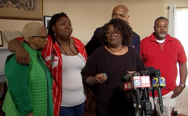 Sheryl Calhoun (third from left) talks to reporters about the death of her husband Charles, who was shot by Clayton County police outside the couple's Jonesboro home early March 23. She's joined by family members and Mawuli Davis, a Decatur attorney representing the family.