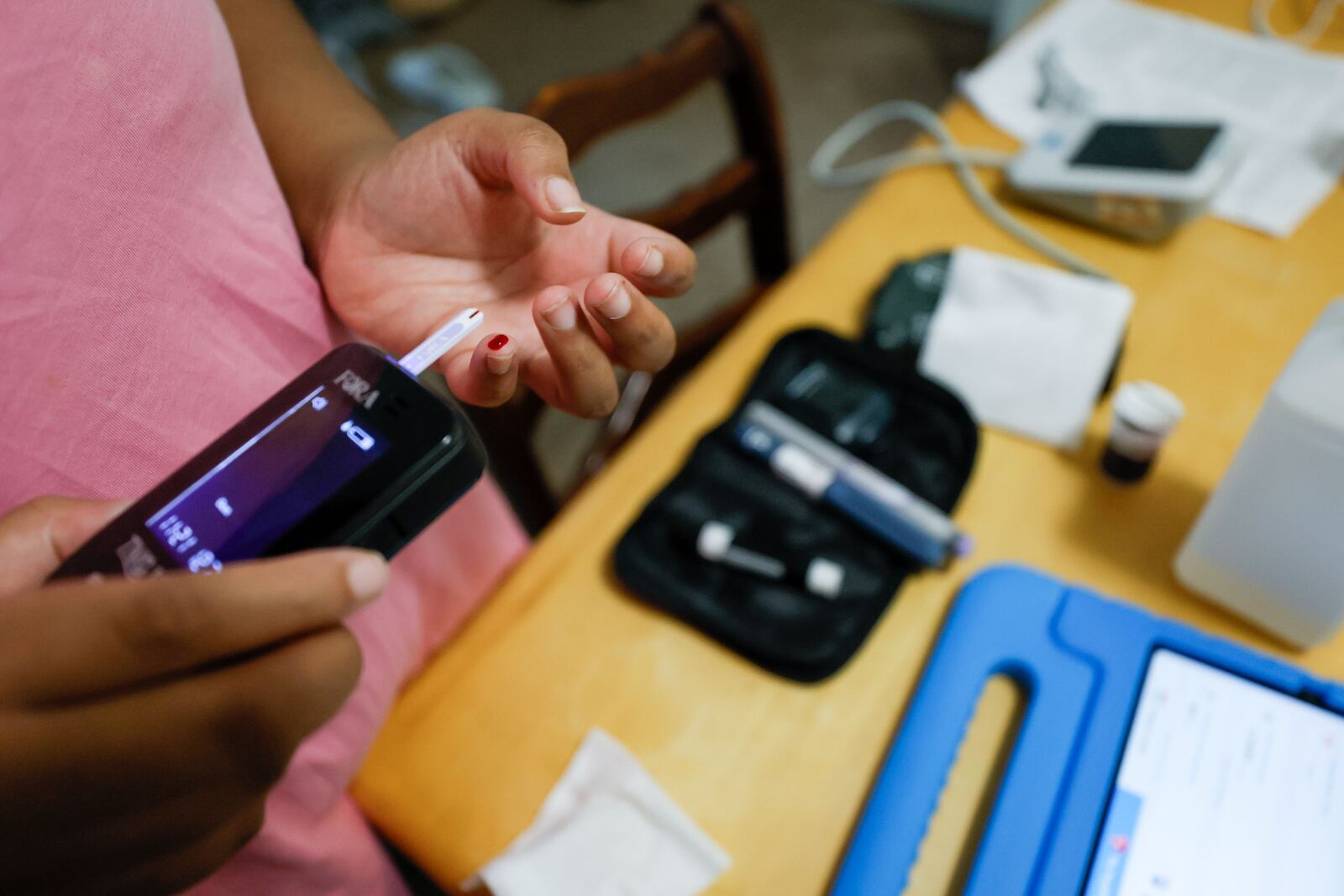 Telemedicine patient Asia Daniels, a patient at Wellstar MCG Health, formerly known as Augusta University Medical Center, starts a glucose test at her house; with just that equipment, a hospital iPad and an internet connection, she can take medical tests and send her results to her healthcare provider without visiting a doctor or nurse.  (PHOTO by Miguel Martinez / miguel.martinezjimenez@ajc.com)