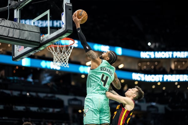 Charlotte Hornets center Nick Richards (4) secures a rebound over Atlanta Hawks guard Vit Krejci, right, during the first half of an NBA basketball game, Saturday, Nov. 30, 2024, in Charlotte, N.C. (AP Photo/Matt Kelley)