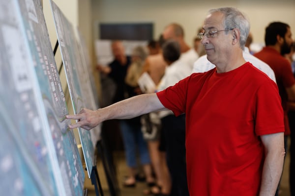 Dunwoody resident Robert Wittenstein examines a map during an open house hosted by the Georgia Department of Transportation to provide info on I-285 top end toll lanes at Dunwoody City Hall. Wittenstein said he would prefer light rail to more toll lanes. “I think this is a missed opportunity,” he said. (Natrice Miller/ AJC)